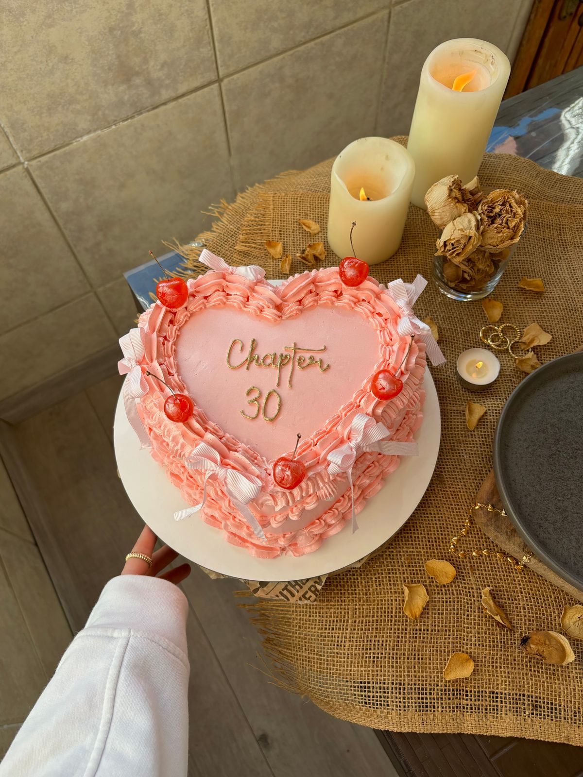 A beautiful heart-shaped cake with cherries and candles, perfect for a 30th celebration.